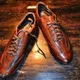 A pair of brown leather shoes on a workbench