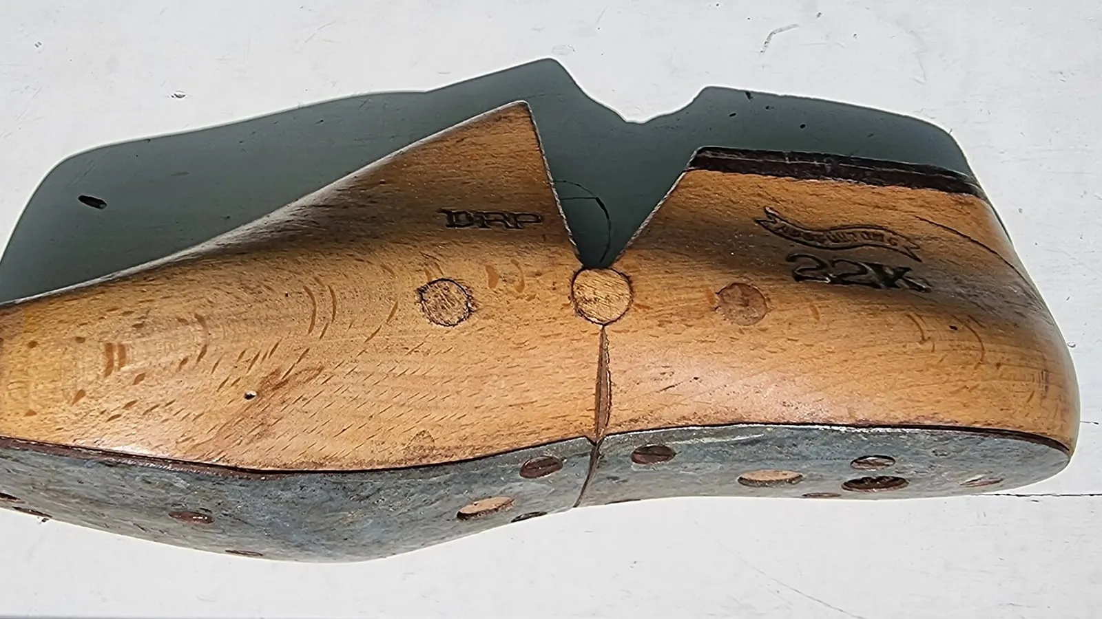 A wooden shoe last stamped with its size, seen from the side